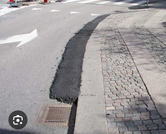 Asfalterad ramp vid trottoarkant förförelse på en väg, möjliggör smidig övergång för fordon från gata till trottoarens nivå.