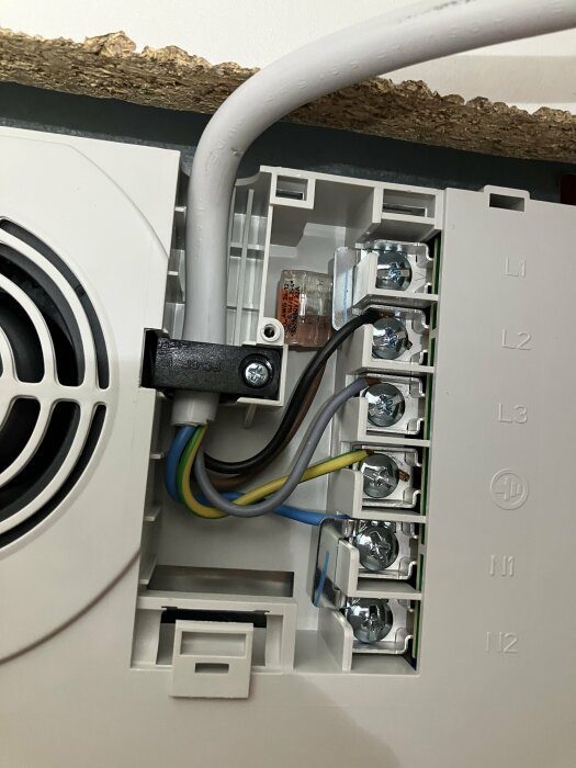 Elektrisk anslutning med kablar där brun hänger fritt, grå är kopplad till L3, och svart är ansluten till L1 och L2.