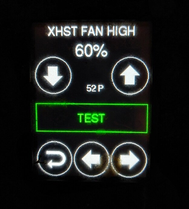 Display med texten "XHST FAN HIGH 60%" och en grön "TEST" knapp, pilar och siffran "52 P", troligen från ett ventilationssystem.