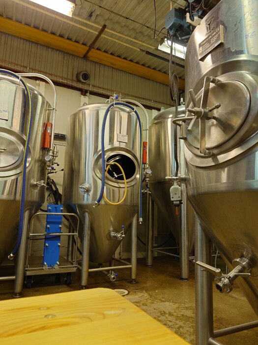 Bryggeritankar hos 5Mans bryggeri i Borlänge, Sverige, med rostfria stålcisterner och rör för bryggning.