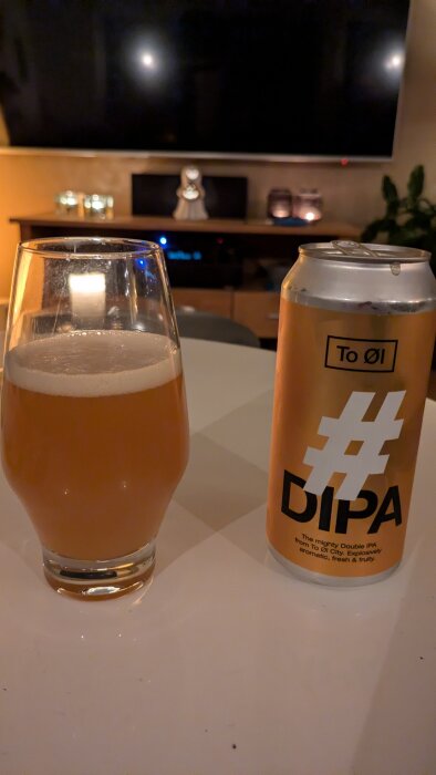 Ett glas med DIPA-öl och en burk med etiketten "To Øl" står på ett bord, förberedelse inför en fixardag på fotbollsplanen.