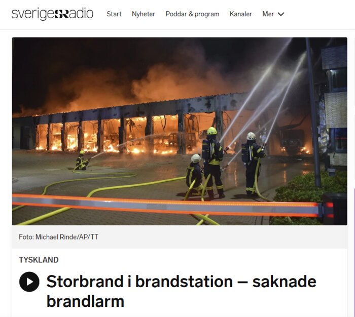 Brandmän bekämpar storbrand i brandstation på natten; byggnaden i lågor.