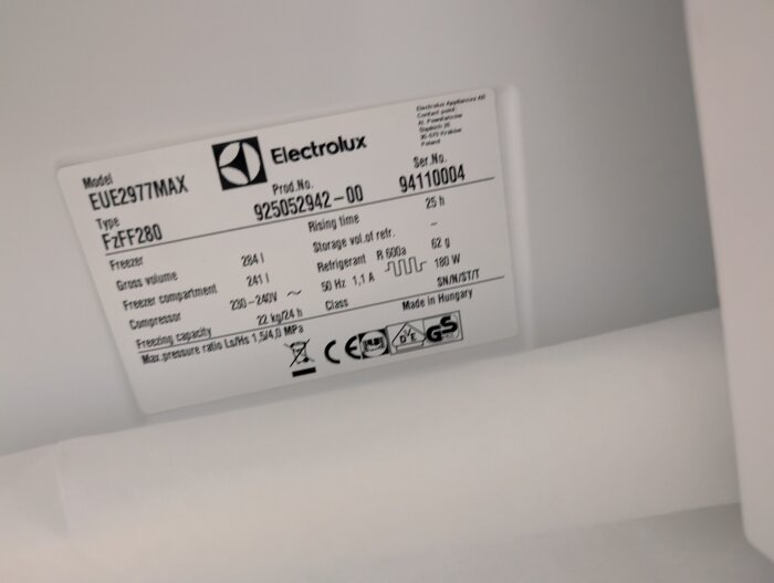 Elektrolux EUE2977MAX frys med modell- och produktnummeretikett, plastkåpan längst in i frysen är utbuktande och markerad som problemområde.