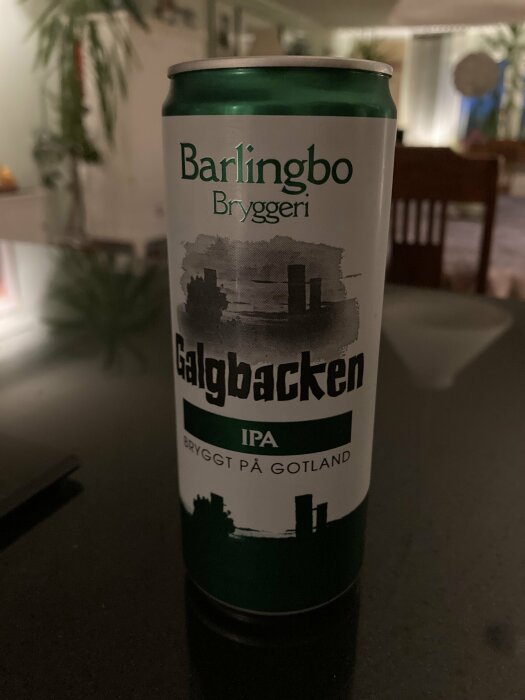 Burk med Barlingbo Bryggeri Galgbacken IPA, bryggt på Gotland, står på ett bord i ett rum med suddig bakgrund.