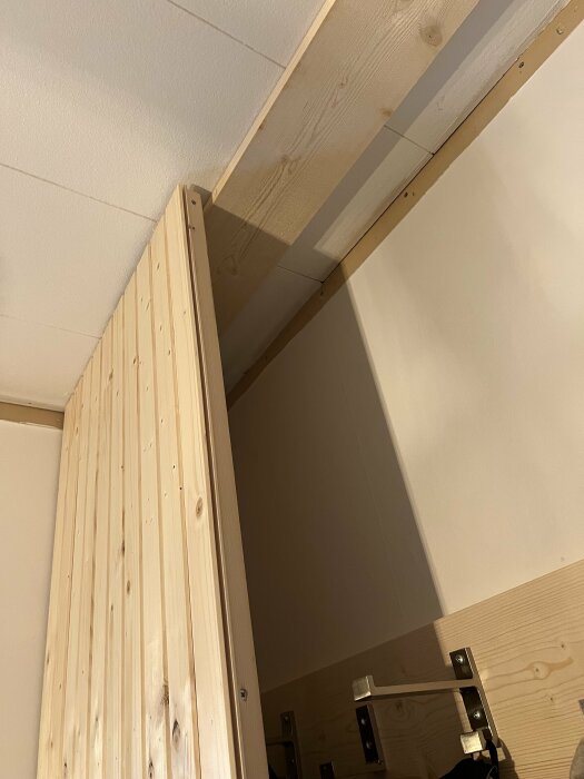 Garderobsdörr av bastupanel med skevhet; högra dörren glipar nere och vänstra uppe, visar problem med dörrarnas stängning.