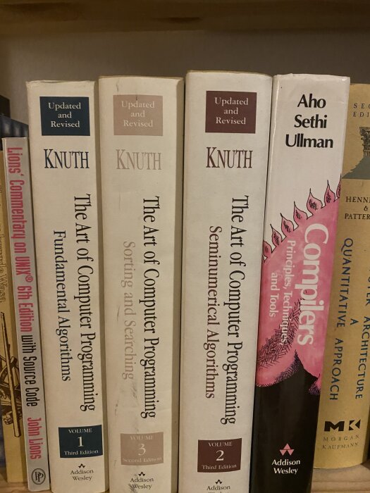 Bokhylla med tekniska böcker, inklusive "The Art of Computer Programming" av Knuth och "Compilers" av Aho, Sethi, Ullman.