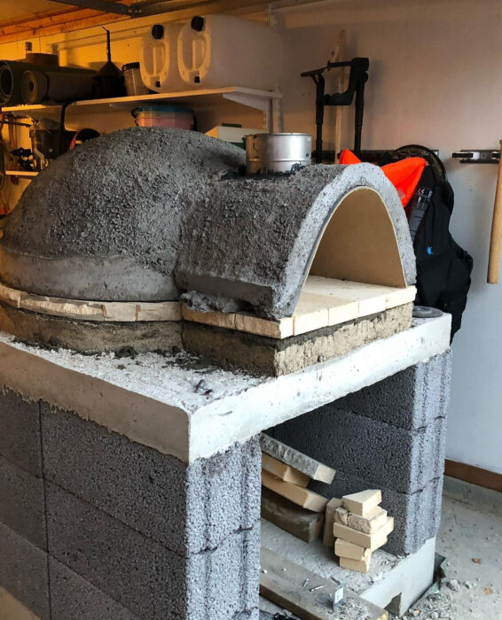 Armerad betonggrund med vermikulit och eldfast tegel används för utomhusugn.