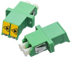 Grön fiberadapter med dubbel LC-kontakt för optisk kablageanslutning, används i nätverksinstallationer för dataförbindelser mellan enheter.