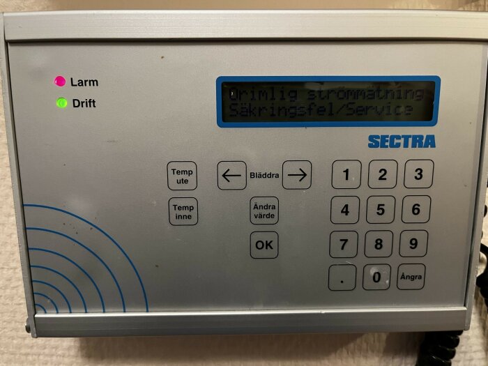 Manöverpanel från SECTRA med felmeddelandet "Orimlig strömmätning/Säkringsfel/Service" och indikatorlamporna "Larm" och "Drift" tända.
