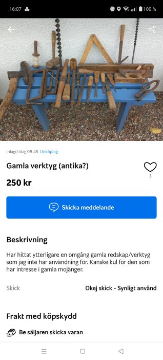 Gamla handverktyg, såsom såg och borr, ligger på en blå bänk utomhus. Verktygen ser välanvända och antika ut.