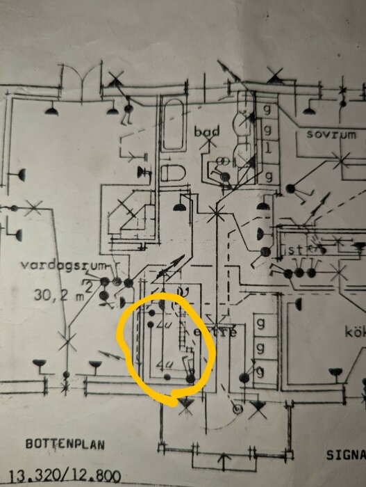 Byggnadsritning med markerade kopplingspunkter, "LU" och strömbrytare brevid trappan med gult markerad cirkel.