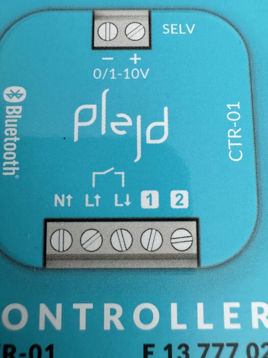 Plejd CRT-01 controller med flera anslutningspunkter markerade: N, L(pil upp), L(pil ner), 1 och 2.