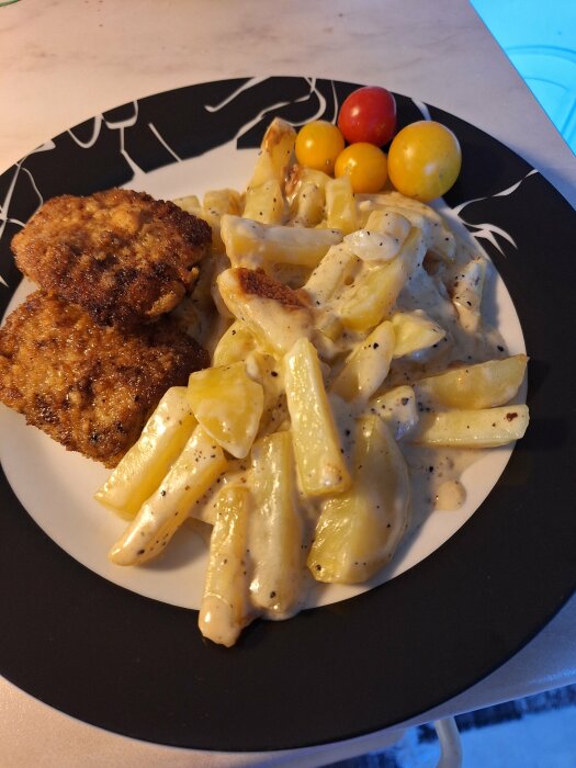 Tallrik med potatisgratäng, hemmagjorda schnitzlar och tomater.