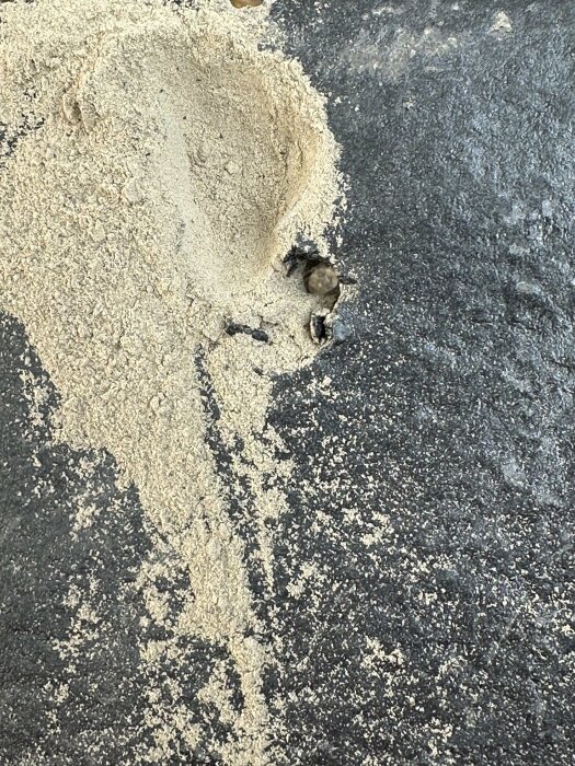 Närbild av takpannor från Benders Carisma med sand och klumpar på ytan, vilket illustrerar sammansättningsproblem med pannorna.