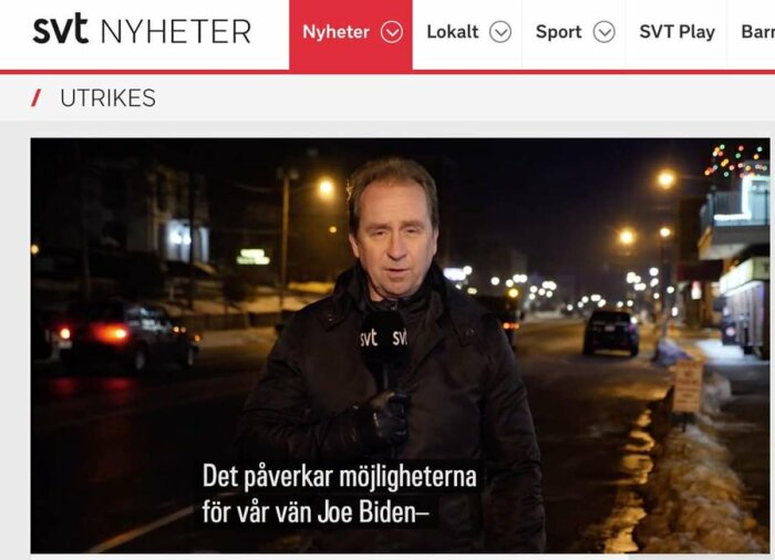 Nyhetsreporter står på en mörk stadsgata med ljus i bakgrunden, SVT-logga på jackan, text på skärmen om "vår vän Joe Biden".