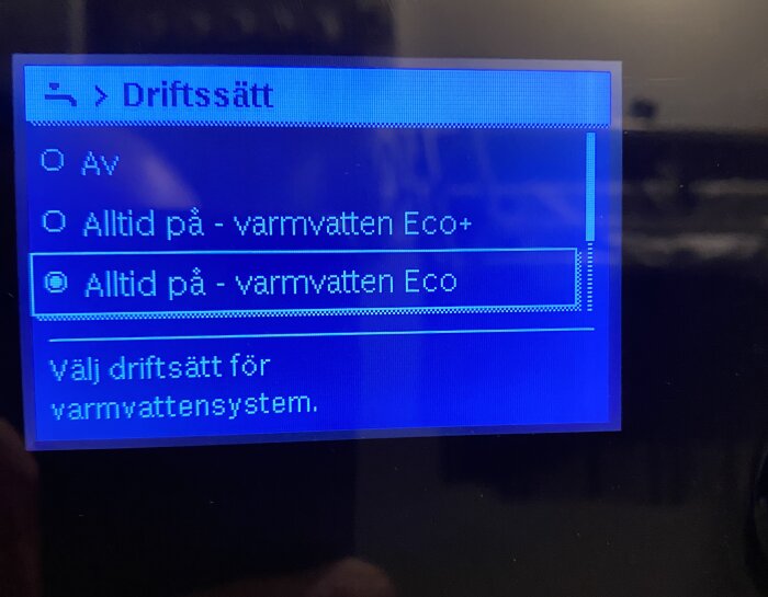 Display med alternativ för varmvattensystem: "Av", "Alltid på - varmvatten Eco+", "Alltid på - varmvatten Eco", där Eco är valt.