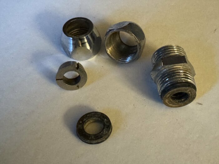 Gängade metallkopplingar och gummipackningar med mässingsbrickor för 10 och 12 mm rör. Möjligen från 70-talet.