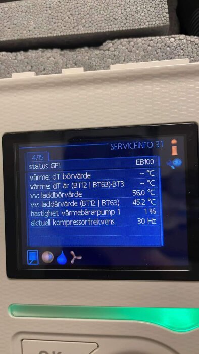 Ett värmepumpsdisplay visar serviceinformation med aktuell data, inklusive laddvärden och kompressorfrekvens. Temperaturer för varmvatten visas.