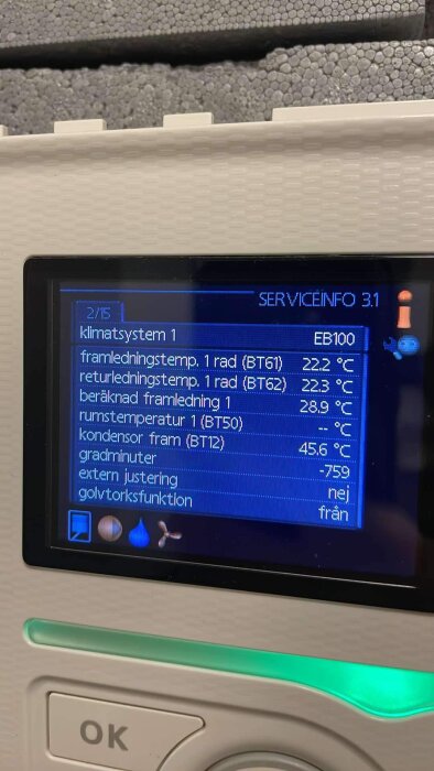 Display på värmepump med servicemeny, visar temperaturer för framledning, returluft och kondensor samt annan systeminformation.