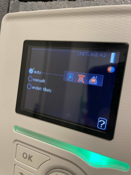 Närbild på display för värmesystem med olika driftlägen: auto, manuellt, och endast tillsats, där "endast tillsats" är valt.