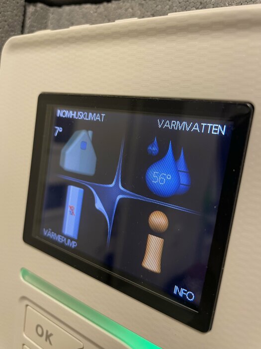 Display på värmepump visar inomhusklimat och varmvattenstatus, 56 grader varmt, med grafiska ikoner för hem, vatten och information.