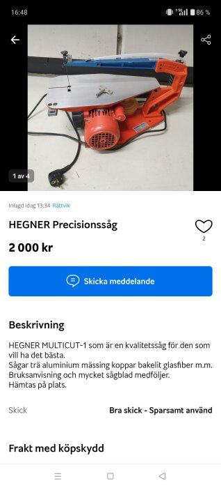 Elektrisk HEGNER precissionssåg med röd bas och metallbord, inklusive elkabel och nyckel på bordet.