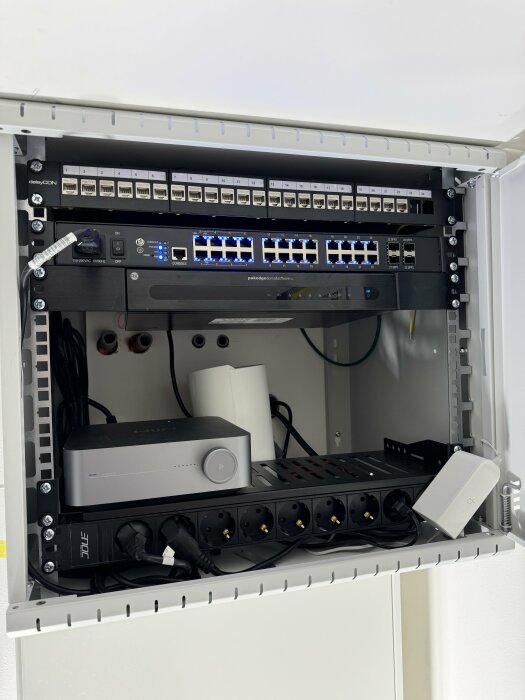 Serverrack med nätverksutrustning och switchar, redo för installation av patchkablar och väggfäste för g5-router i serverrummet.