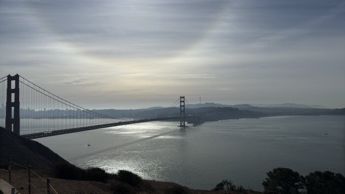 Golden Gate-bron i San Francisco med solnedgången i bakgrunden över bukten och omgivande landskap.