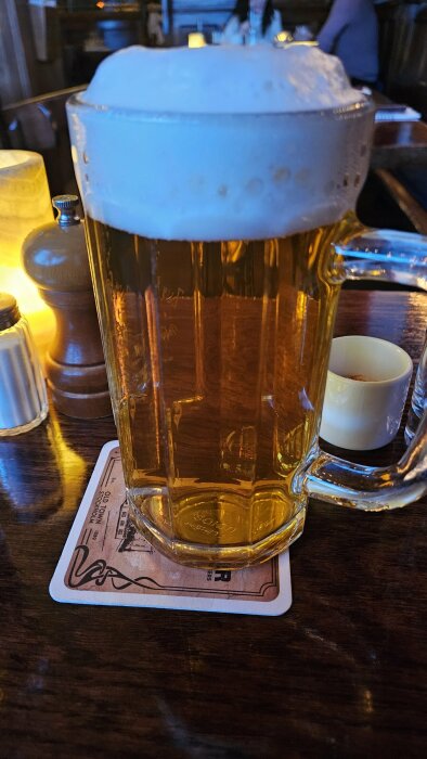 Stor ölsejdel med skummande Självrunnen Hausbrauer från Günther Bräu på ett bord i en pubmiljö.