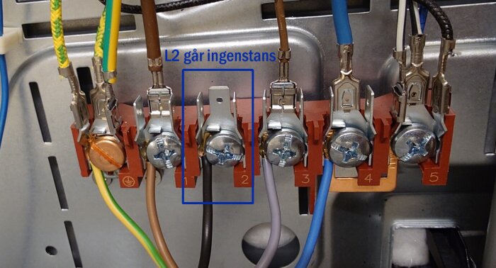 Närbild av elektrisk anslutning med flera färgade kablar och märkningen "L2 går ingenstans" för en oansluten kabel.