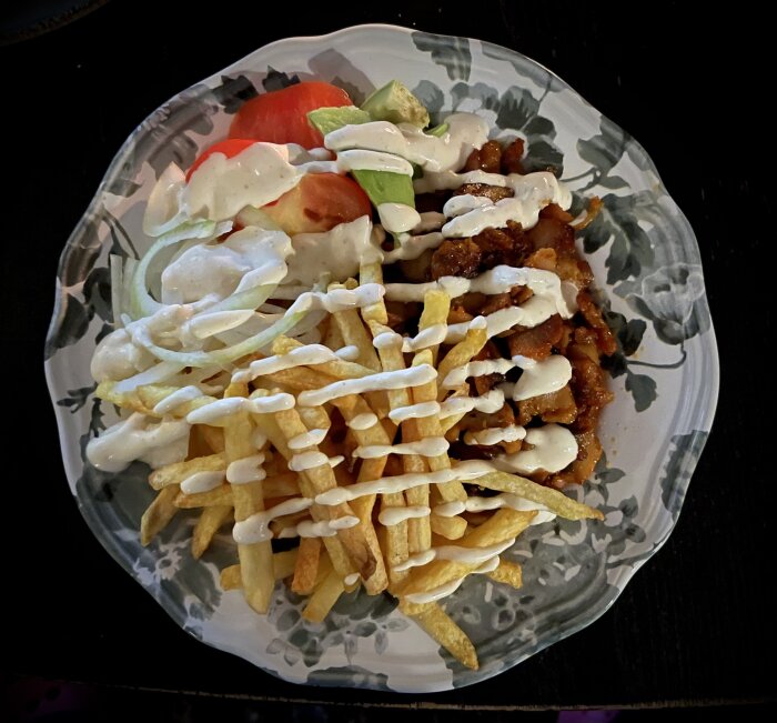 Tallrik med kycklingkebab, grönsaker, pommes frites och vitlökssås.