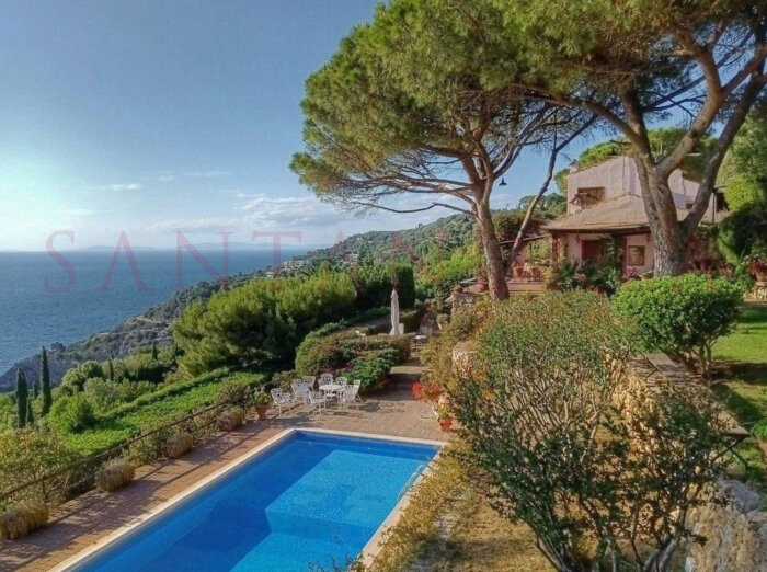 Villa med pool och terrass i Monte Argentario, Toscana, med utsikt över havet och omgiven av grönska.