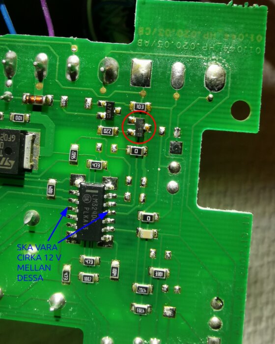 Närbild av ett kretskort med en inringad transistor och en pil som pekar på en annan komponent, texten anger att spänningen ska vara cirka 12V.