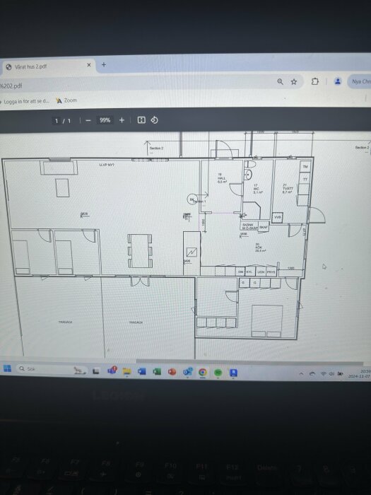 Planlösning av husets kök och vardagsrum med markerade områden för hall, wc och tvättstuga. Inklusive köksö och plats för kyl, frys.