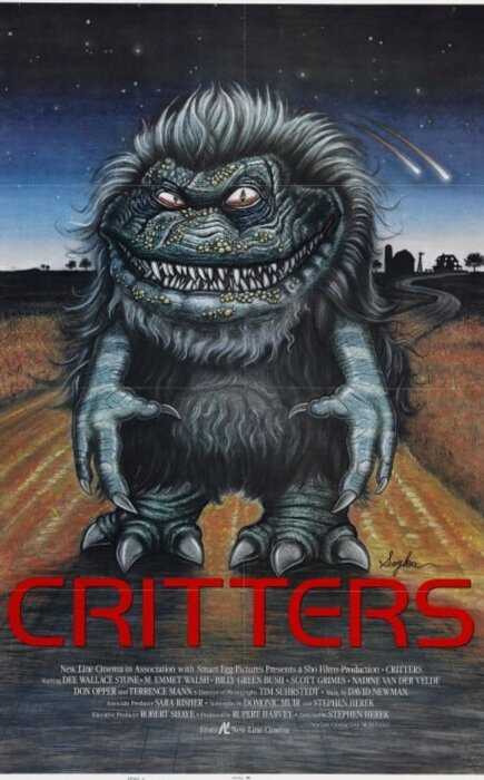 Affisch för filmen "Critters" med en tecknad bild av ett monster med stort leende och klor på en landsväg under en stjärnklar natthimmel.