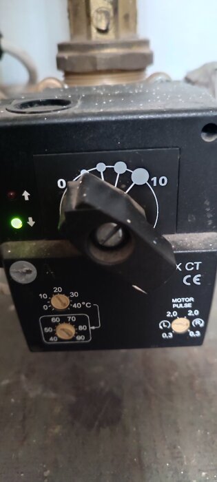 Termostatreglage med ratt och graderingsskala, inställd mellan 0 och 10. LED-indikator ljusgrön. Två skruvreglage för temperatur och motorpuls.