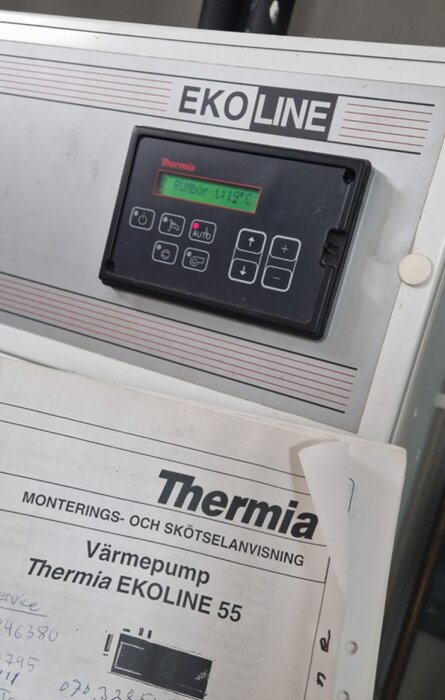 Värmepumpens kontrollpanel med display och instruktion för bergvärmepump Thermia Ekoline 55.