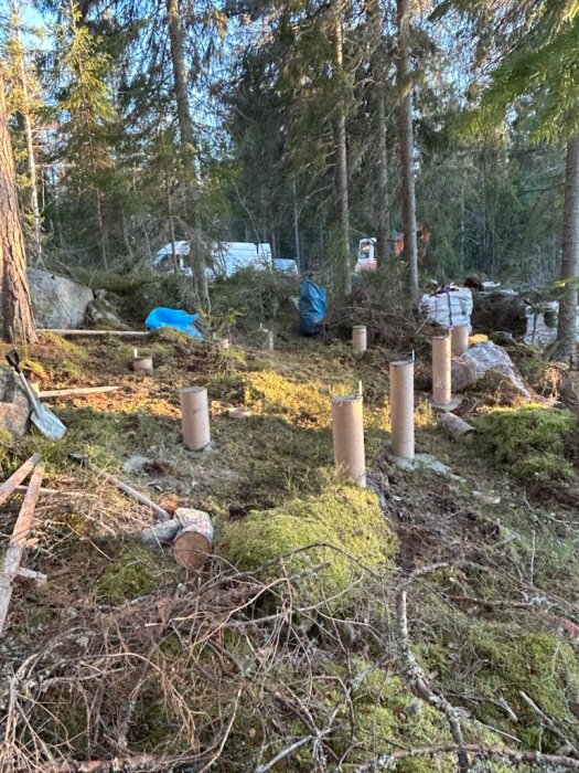 Betongplintar i en skog för grundläggning av friggebod.