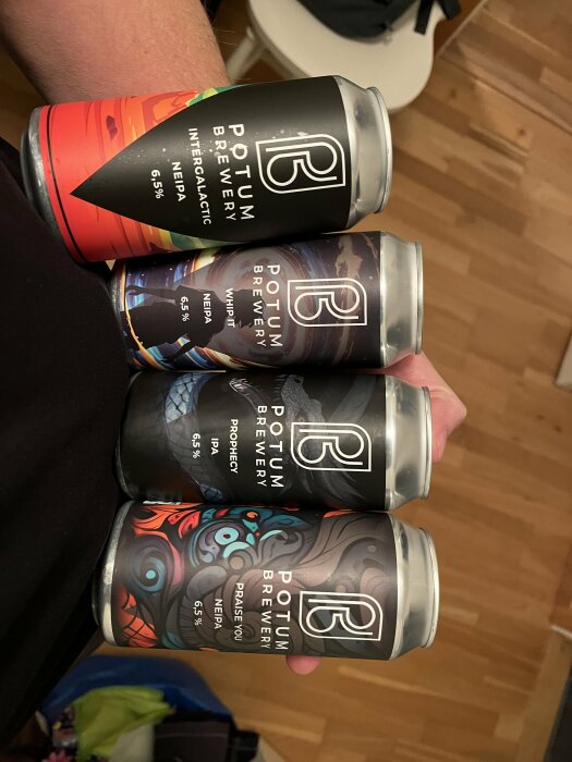 Fyra olika ölsorter från Potum Brewery, hållna i handen, med färgglada etiketter och 6,5% alkoholhalt.