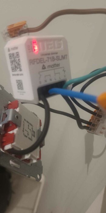 Elektronisk dimmerinstallation med kablar anslutna till RFDEL-71B-SLMT-modulen, med röd lysdiod aktiv.