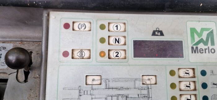 Kontrollpanel av en Merlo-fordon med knappar märkta "P", "1", "N" och "2", samt en växelspak i förgrunden.