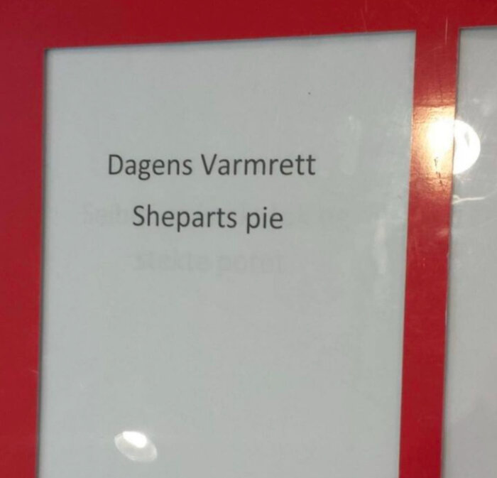 Textskylt med "Dagens Varmrätt" och "Sheparts pie" i svart text på vitt papper med röd ram.