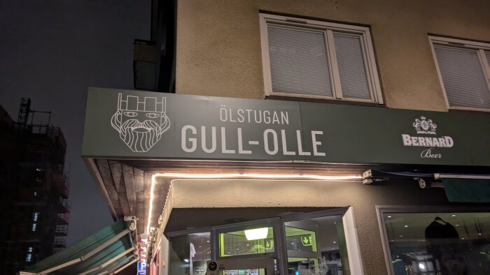 Skylt ovanför puben "Gull-Olle" i Norrköping, med logotyp av en skäggig man med krona, samt Bernard Beer-logotyp.