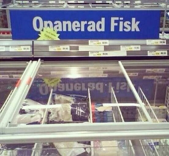 Skylt i en mataffär som visar "Opanerad Fisk" ovanför en frys med frysta fiskprodukter.