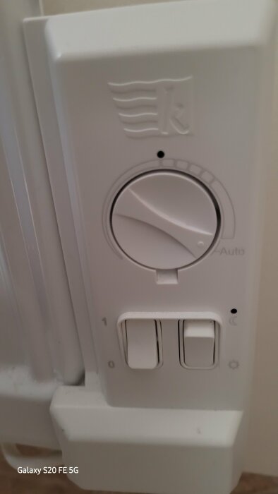 Termostatpanel med vred och strömbrytare för manuell och automatisk inställning av värme på en radiator.