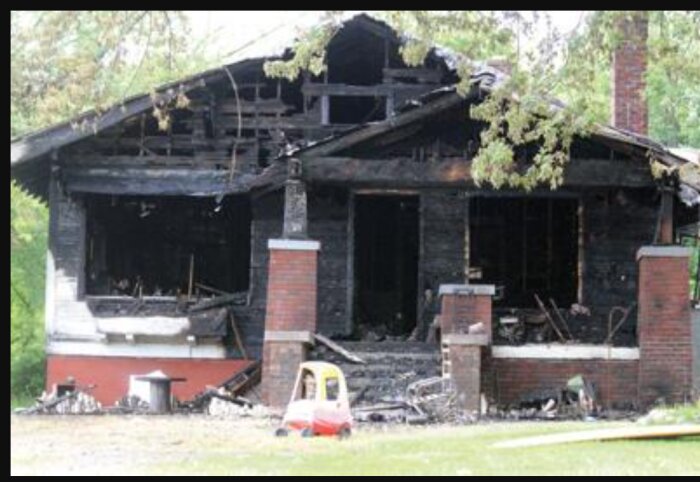 Bränt och skadat hus som antagligen drabbats av brand, med svartnad fasad och förstörd interiör.