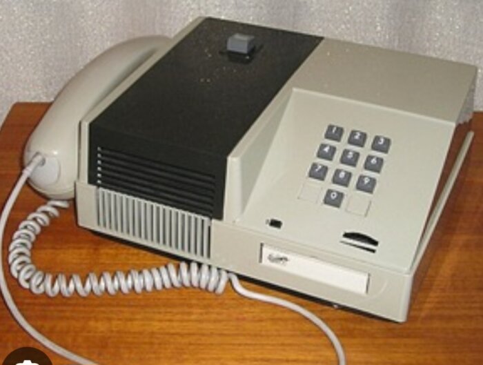 Vintage Ericsson telefon från 1979 med knappsats, pulsringning och högtalarfunktion, placerad på ett träbord.