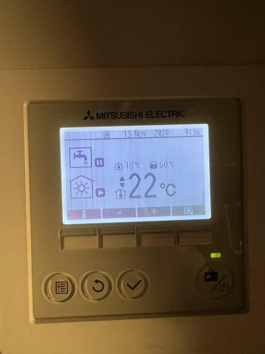 Närbild av kontrollpanelen på en Mitsubishi Ecodan värmepump, inställd på 22°C med innetemperaturen visande 18°C och ett inlopp på 60°C.