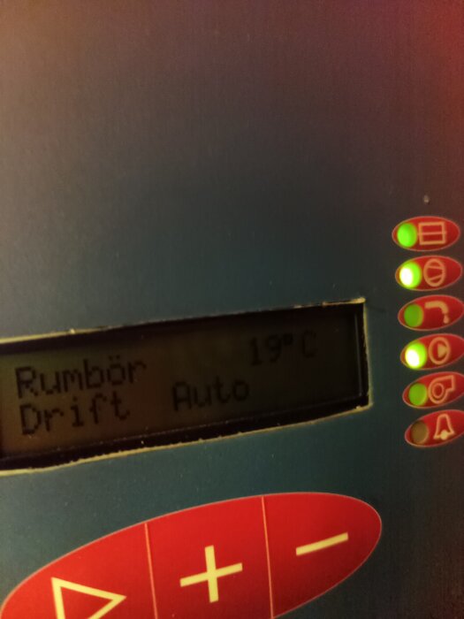 Display av termostat, visar "Rumbör 19°C" och "Drift Auto" med lysande indikatorlampor på sidan.