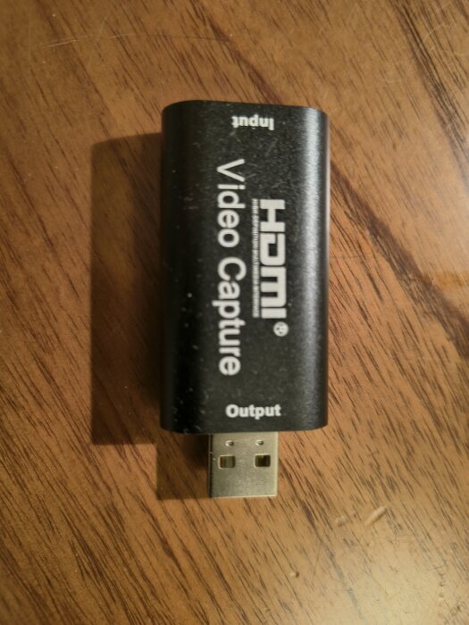 USB Video Capture-enhet på ett trägolv.